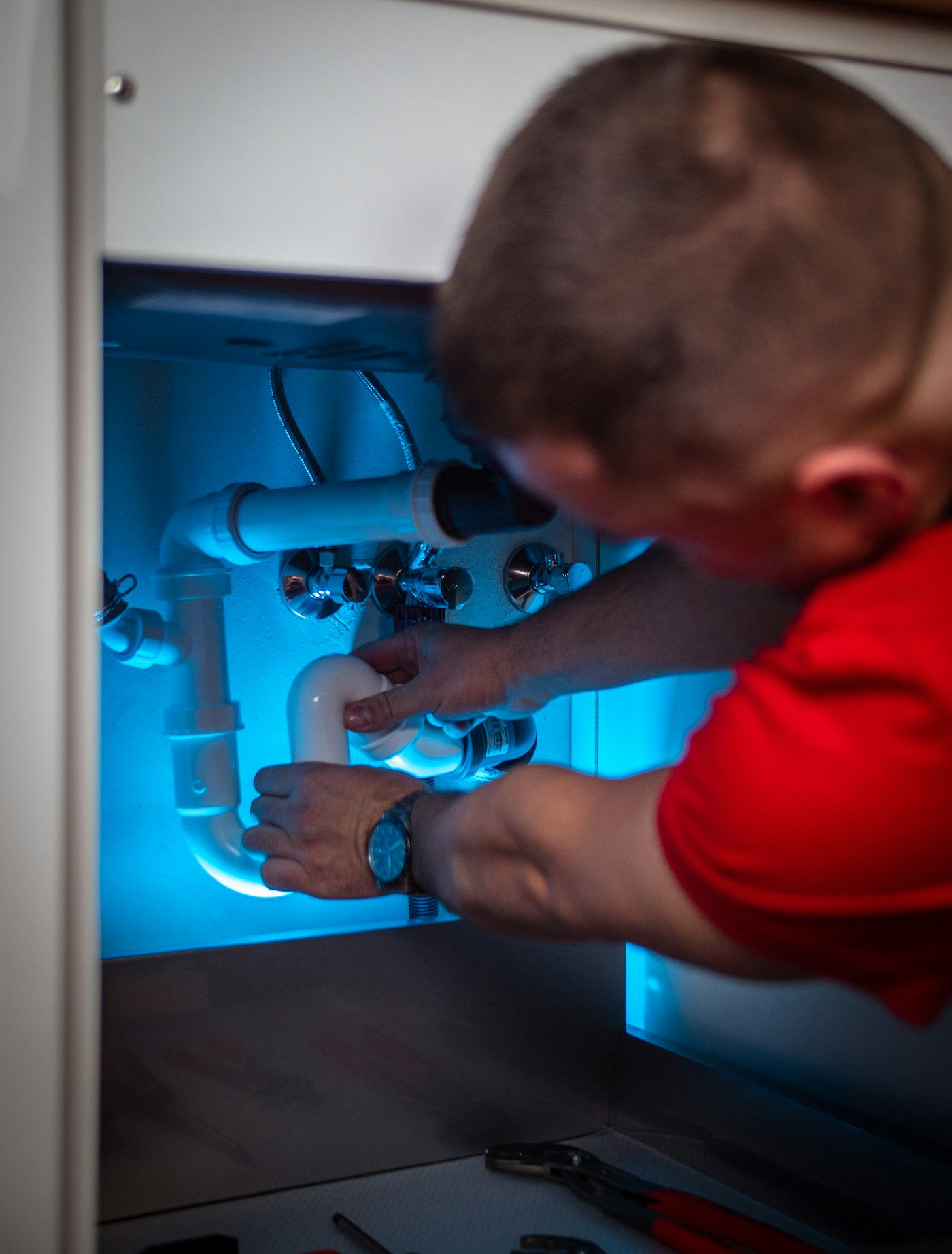 Installateur schließt einen Abfluss unter einem Waschbecken an